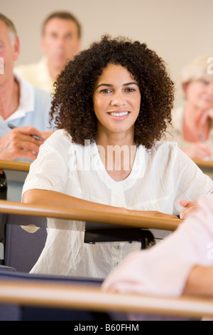 Frau sitzt in Erwachsenen Klasse mit Schülern im Hintergrund (Tiefenschärfe) Stockfoto