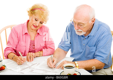Älteres paar ausfüllen abwesender Stimmzettel zu Hause isoliert auf weiß Stockfoto