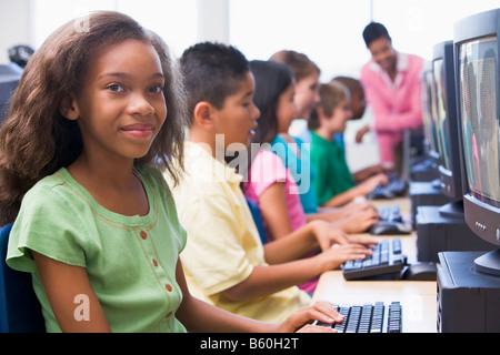 Sechs Kinder am Computer-Terminals mit Lehrer im Hintergrund (Schärfentiefe-Bereich/High-Key) Stockfoto