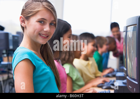 Sechs Kinder am Computer-Terminals mit Lehrer im Hintergrund (Schärfentiefe-Bereich/High-Key) Stockfoto