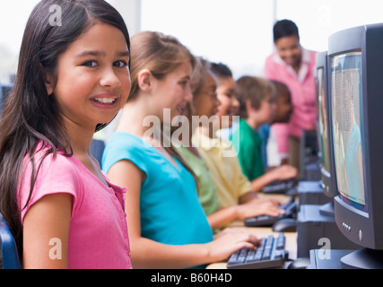 Sechs Kinder am Computer-Terminals mit Lehrer im Hintergrund (Schärfentiefe-Bereich/High-Key) Stockfoto