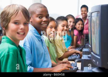 Sechs Kinder am Computer-Terminals mit Lehrer im Hintergrund (selektiven Fokus/High-Key) Stockfoto