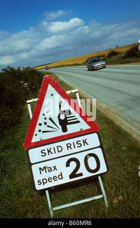 Warnsignal für rutschige Fahrbahn auf neu sanierten Straße in der Nähe von Leeds Yorkshire UK vorbeifahrende Autos