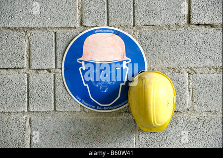 Arbeitshelm hängen an einer Wand neben einem Schutzhelm Bereich Sicherheitszeichen Stockfoto