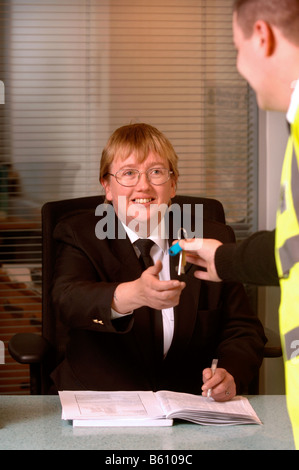 EIN WACHMANN AUF PATROUILLE PÄSSE-TASTEN, UM EINE FRONT DESK SECURITY OFFICER AT A BUSINESS RÄUMLICHKEITEN UK Stockfoto