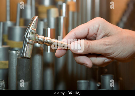 Hand mit einem tuning Hammer über die Orgelpfeifen einer privat restaurierten Kirchenorgel, Orgelhof Goldelund, Nordfriesland Stockfoto