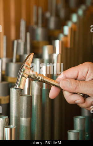 Hand mit einem tuning Hammer über die Orgelpfeifen einer privat restaurierten Kirchenorgel, Orgelhof Goldelund, Nordfriesland Stockfoto