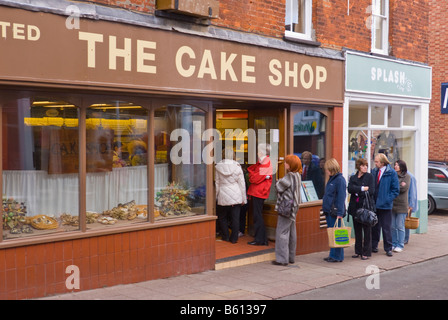 Kunden Queing up in Que außerhalb eine beliebte Bäckerei namens die Konditorei in Woodbridge, Suffolk, Uk Stockfoto