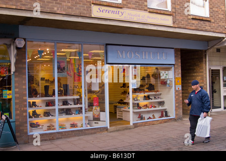 Mann zu Fuß hinter dem Moshulu Schuh und Schuhe Shop Geschäft in Woodbridge, Suffolk, Uk Stockfoto