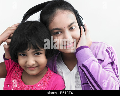 Porträt von zwei asiatischen Schwestern anhören von Musik mit einem Kopfhörer Stockfoto