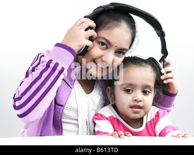 Porträt von zwei asiatischen Schwestern anhören von Musik mit einem Kopfhörer Stockfoto
