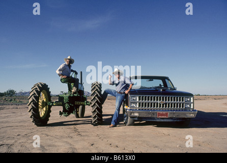 Landwirt und Künstler Carl Clapp, in einen Pickup-Truck Verhandlungen für eine mexikanische Einwanderer Landarbeiter auf einem John Deere Traktor auf seinem Baumwollfarm in der Nähe von Phoenix, Arizona Stockfoto