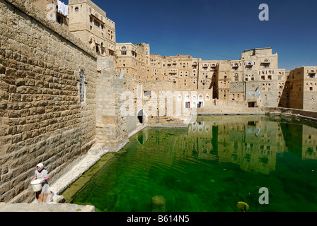 Arabische Mädchen holen Wasser aus der Zisterne in Habbaba, Jemen, Arabien, Arabische Halbinsel, im Nahen Osten Stockfoto