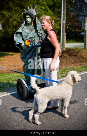 Eine Frau gekleidet wie die Freiheitsstatue auf einem Segway steht vor dem 4. Juli parade durch Irvington, VA. Stockfoto