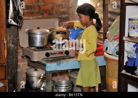 Mädchen füllen ihre Teller in eine schlechte Küche, Slum Gegend planen 3000, Santa Cruz, Bolivien, Südamerika Stockfoto