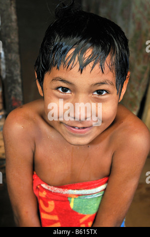 Nasse junge kommt aus der Dusche, eingewickelt in ein Handtuch, Slum Gegend planen 3000, Santa Cruz, Bolivien, Südamerika Stockfoto