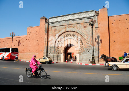 Verschleierte Autofahrerin ein Moped hinter dem Tor Bab Agnaou in Marrakesch, Marokko, Afrika Stockfoto