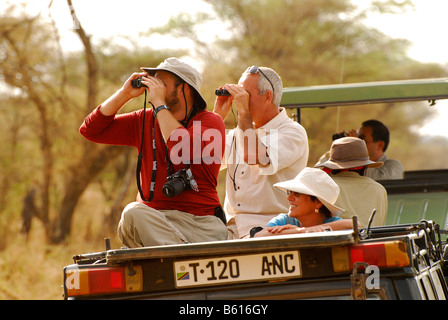 Touristen, die Beobachtung der Tierwelt im Serengeti Nationalpark, Tansania, Afrika Stockfoto