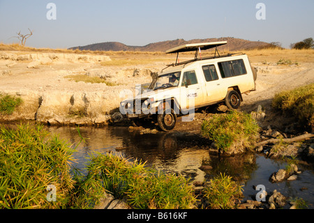 Fahrzeug über den Verlauf eines Flusses, Serengeti Nationalpark, Tansania, Afrika Stockfoto