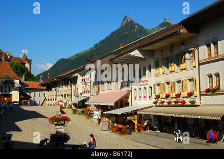 Main Street in das mittelalterliche Städtchen Gruyères, Greyerz, Mt Dent du Bruc und Mt Dent du Chamois in den Rücken, Kanton Freiburg Stockfoto