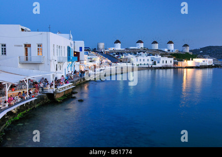 Touristen sitzen in den Restaurants in Little Venice, Windmühlen, Abend Stimmung, Insel Mykonos, Kykladen, Griechenland, Europa Stockfoto