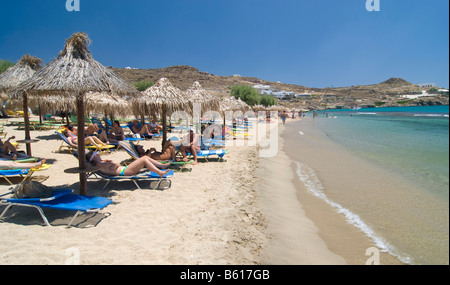 Super Paradise Beach, Touristen entspannen Sie sich auf Liegestühlen unter Sonnenschirmen, Mykonos, Kykladen, Griechenland, Europa Stockfoto