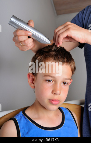 Neun Jahre alten Jungen bekommen einen neuen Haarschnitt Stockfoto