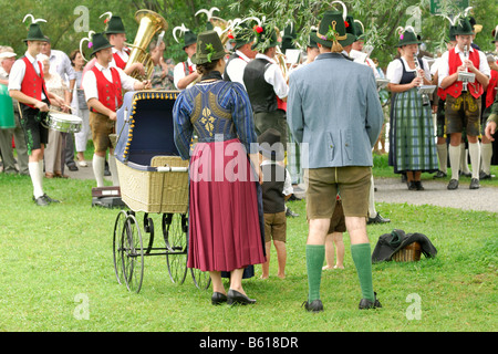 Familie in traditionellen Kostümen mit einem historischen Kinderwagen in der Alt-Schliersee Churchday, See Schliersee, Oberbayern Stockfoto