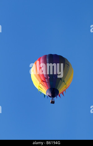 Regenbogen farbige angebunden oder Gefangenschaft Heißluftballon vor blauem Himmel Stockfoto