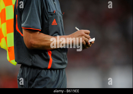 Linienrichter ein Foul in seinem Notizbuch während eines Fußballspiels in Anbetracht Stockfoto