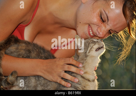 Jung grau Tabby Katze Knutschen mit einer Frau Stockfoto