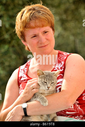 Junge graue Tabbykatze genießen von einer Frau gestreichelt Stockfoto