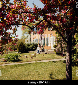 Paar, sitzen auf Stufen vor Haus in ländlichen Ontario Century Home, Ontario; Kanada Stockfoto