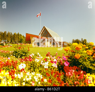 Alexander Graham Bell Museum in Cap Breton Nova Scotia, Kanada mit Blumenbeet mit kanadische Flagge und Haus im Hintergrund Stockfoto
