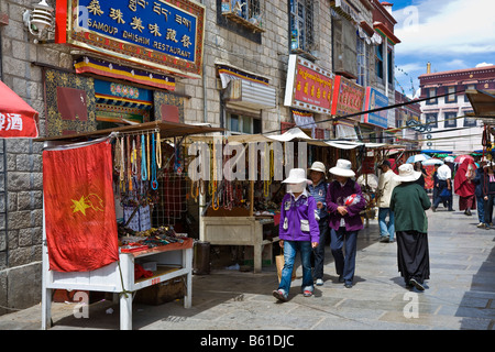 Tibeter vorbeigehen Markt Stände verkaufen touristische Souvenirs und Schmuck in der Barkhor Square Lhasa Tibet JMH3661 Stockfoto