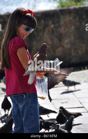 ein kleines Mädchen füttert eine Taube, der landet auf dem Arm in der Altstadt von San Juan, Puerto rico Stockfoto