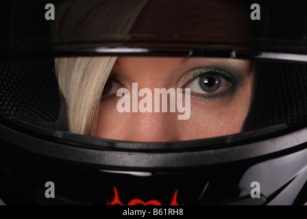 Junge blonde Frau trägt ein Motorrad-Helm, Visier, Augen Stockfoto