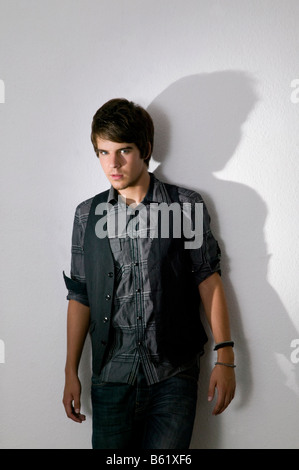 Junger Mann selbstbewusst vor einer Wand stehend Stockfoto