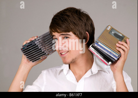 Junger Mann hält CDs in seinen Ohren Stockfoto