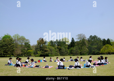 Schülerinnen und Schüler in der Uniform eines elitären Grundschule während des Mittagessens brechen im Botanischen Garten in Kyoto, Japan, Stockfoto