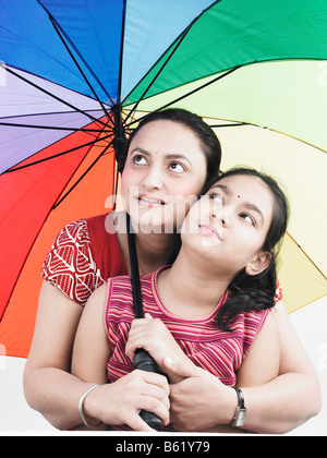 Mutter und Tochter mit einem mit Regenbogen Regenschirm Stockfoto