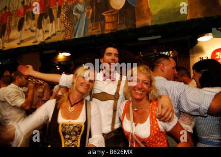 Frauen tragen traditionelle Kleidung, genannt ein Dirndl, Tanz im Bierzelt auf der Wiesn Bierfest oder Wies'n in München Stockfoto