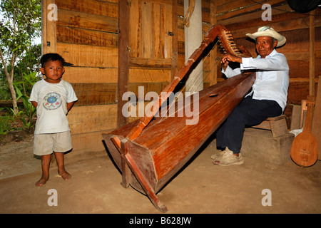 Einheimische Musiker spielt einen selbstgebauten Instrument, Harfe, kleiner Junge, Holzhütte, Punta Gorda, Belize, Mittelamerika Stockfoto