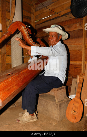 Einheimische Musiker spielt einen selbstgebauten Instrument, Harfe, Holzhütte, Punta Gorda, Belize, Mittelamerika Stockfoto
