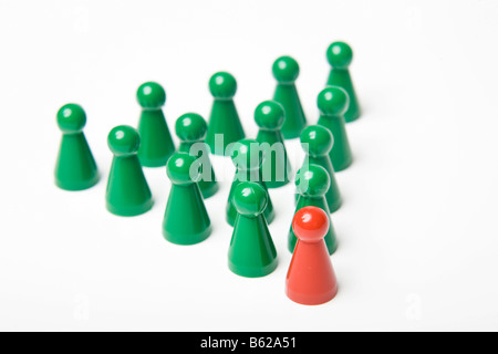 Grünen Spielsteine hinter einen einzigen roten Stein, symbolische Führung Stockfoto