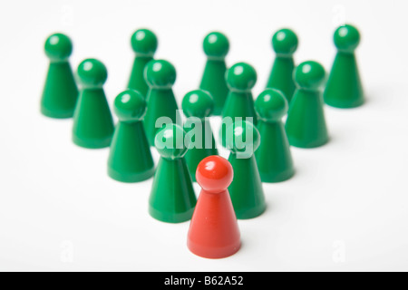 Grünen Spielsteine hinter einen einzigen roten Stein, symbolische Führung Stockfoto