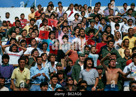 Soldaten und Publikum bei einem Fußballspiel entsprechen Jubel von den Stadion-Terrassen Tirana Albanien 1992 Stockfoto