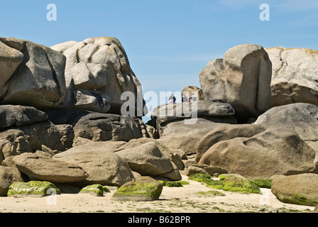 Menschen im Urlaub sitzt auf einer Felsformation in der Nähe der Phare de Pontusval, Brignogan, Bretagne, Frankreich, Europa Stockfoto