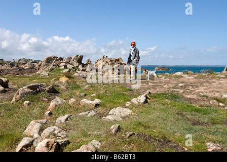 Frau zu Fuß ihr Jack Russel Terrier entlang der felsigen Küste in der Nähe von Le Diben, Bretagne, Bretagne, Frankreich, Europa Stockfoto