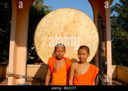 Buddhistischen Novizen steht vor einem großen, runden Trommel, Wat Phonxay, Vientiane, Laos, Südostasien Stockfoto